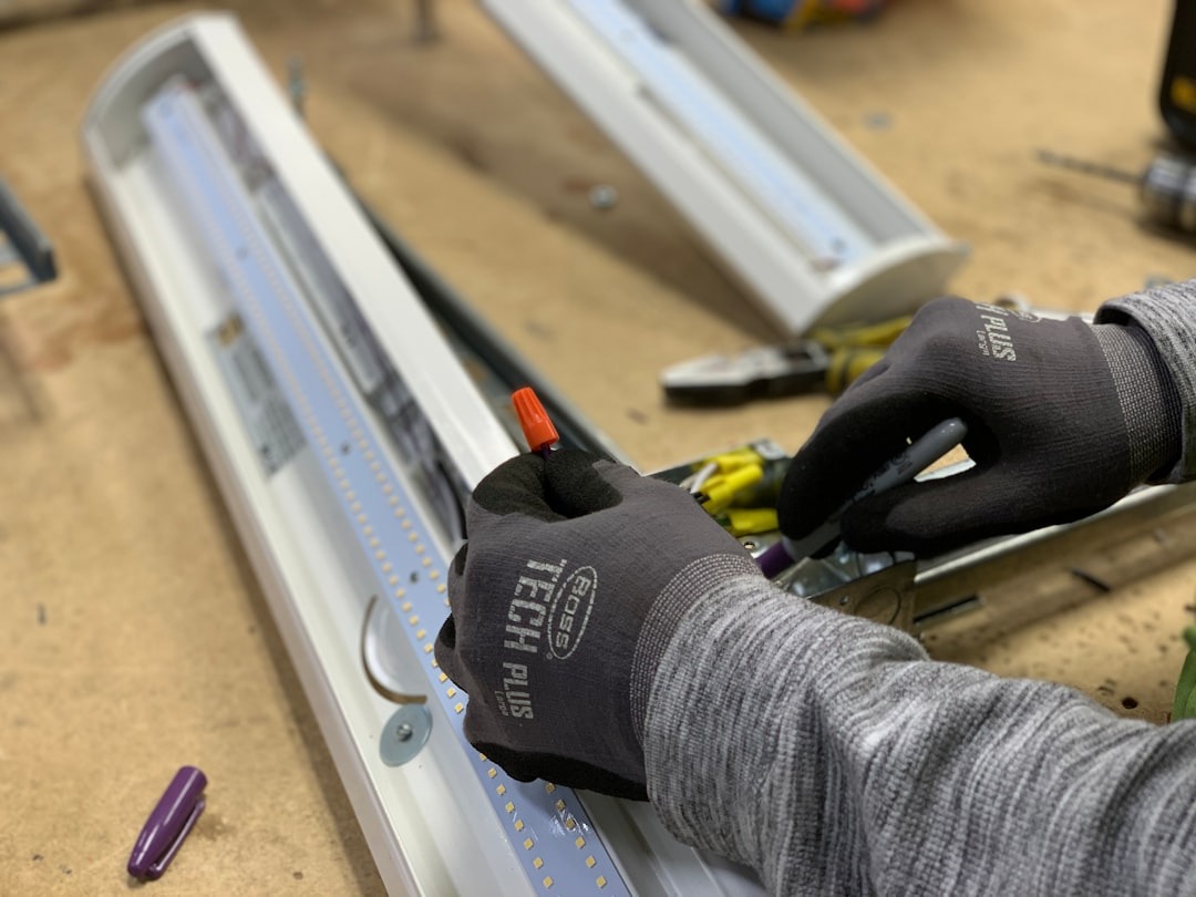 Technician connects wires with an orange wire nut to LED light.